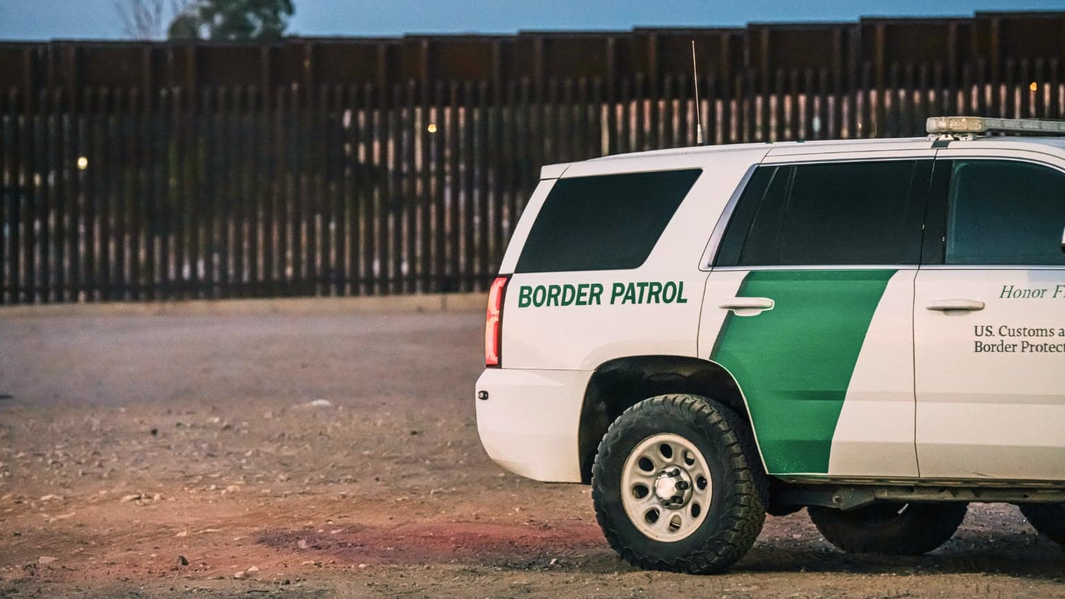 A Border Control truck in front of a border fence