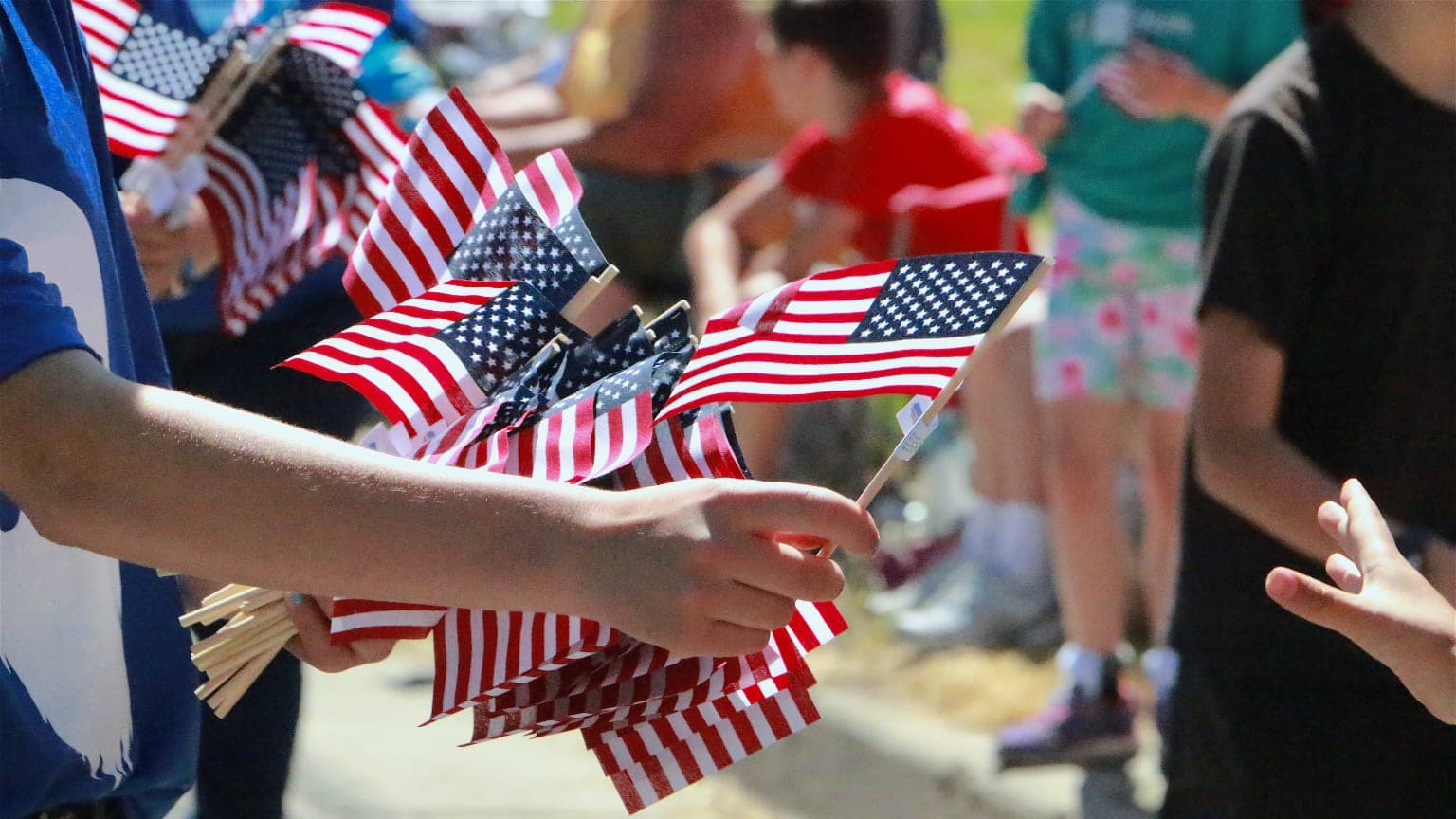 Small U.S. flags being passed out at a parade