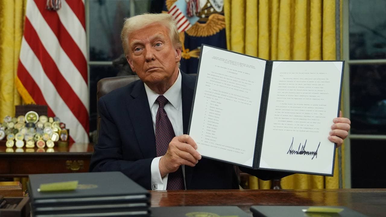 President Trump holds up pardon document with his signature on it